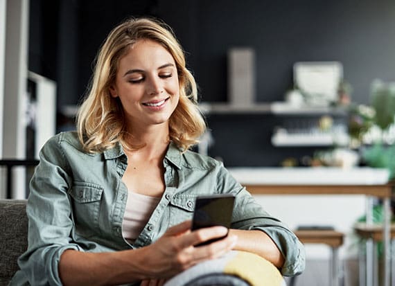 female wearing blue shirt having her online Telehealth consultation from her home