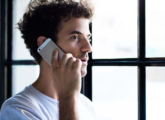 male in blue having a phone call through his iPhone