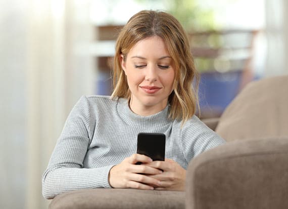 female wearing blue shirt having her online Telehealth consultation from her home