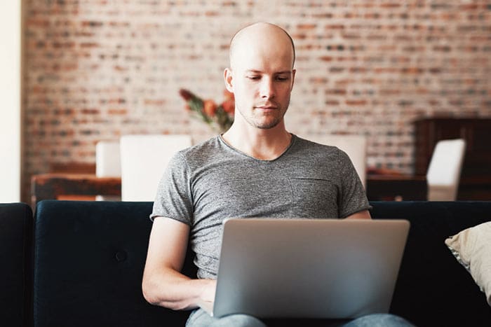 a male wearing grey shirt having his online Telehealth consultation from his home
