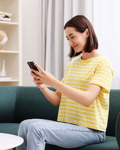 female wearing yellow shirt having her online Telehealth consultation from her home