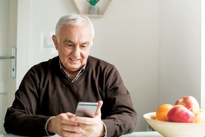 Senior citizen wearing bown shirt having her online Telehealth consultation from his home