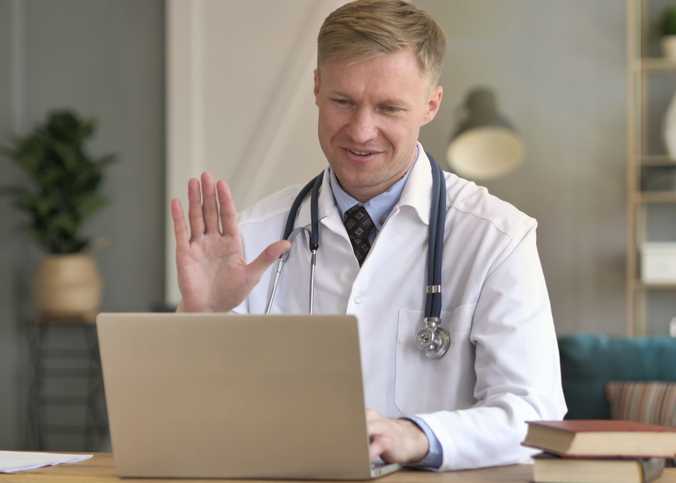 Doctor waving to patient during Telehealth appointment