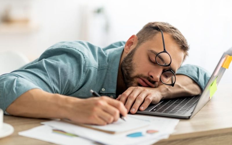 Exhausted man sleeping on his work desk