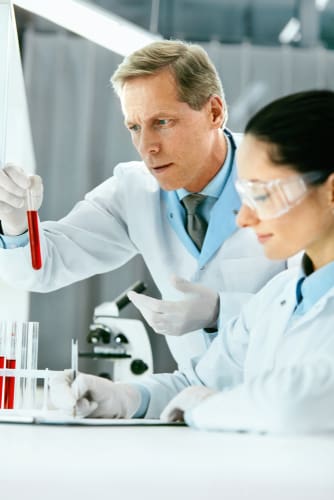 male and female pathologists analysing blood test samples of a patient
