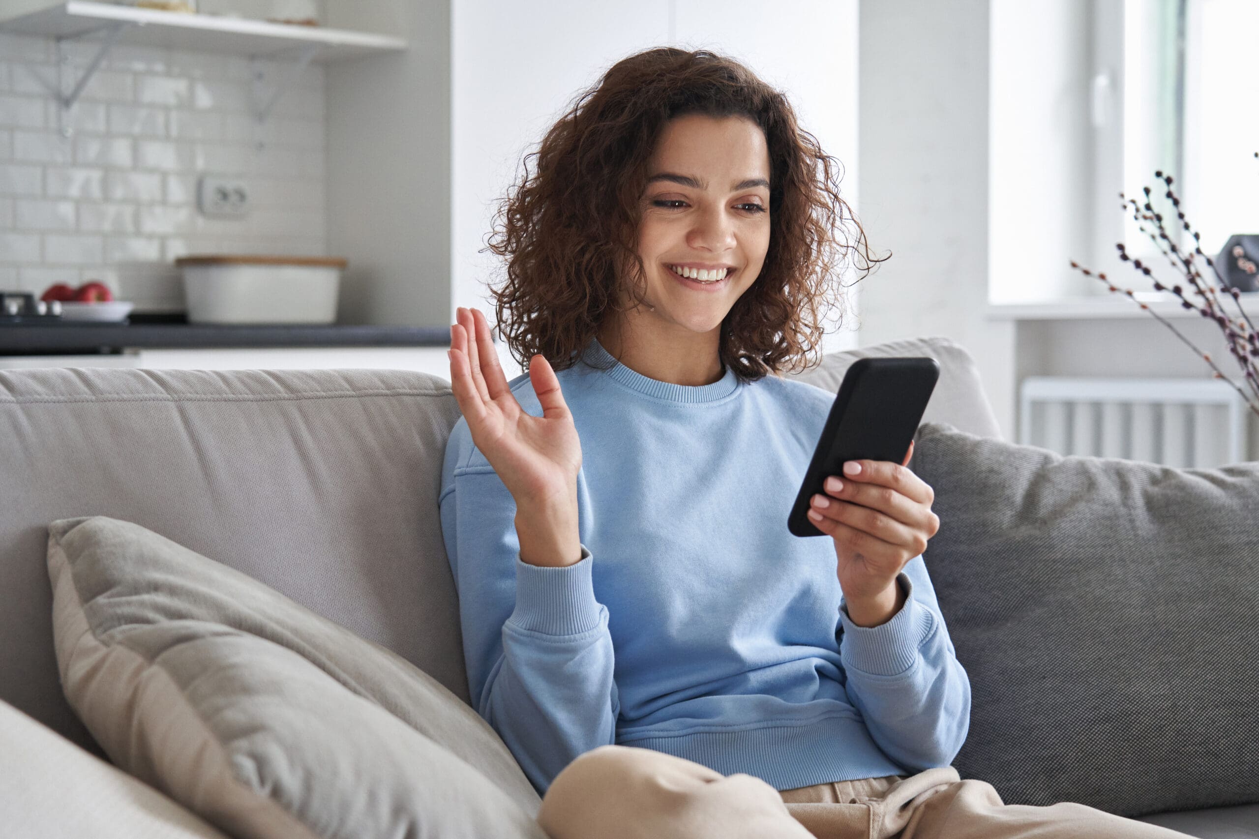 female wearing blue shirt having her online Telehealth consultation from her home