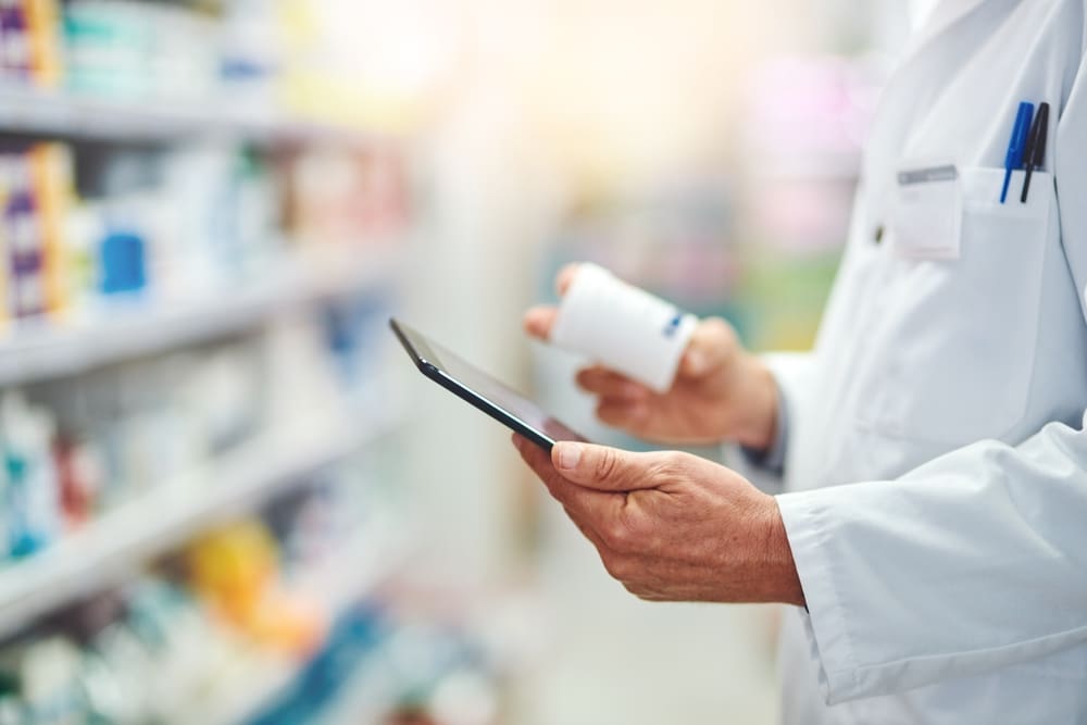 pharmacist checking script orders and medication in a pharmacy store