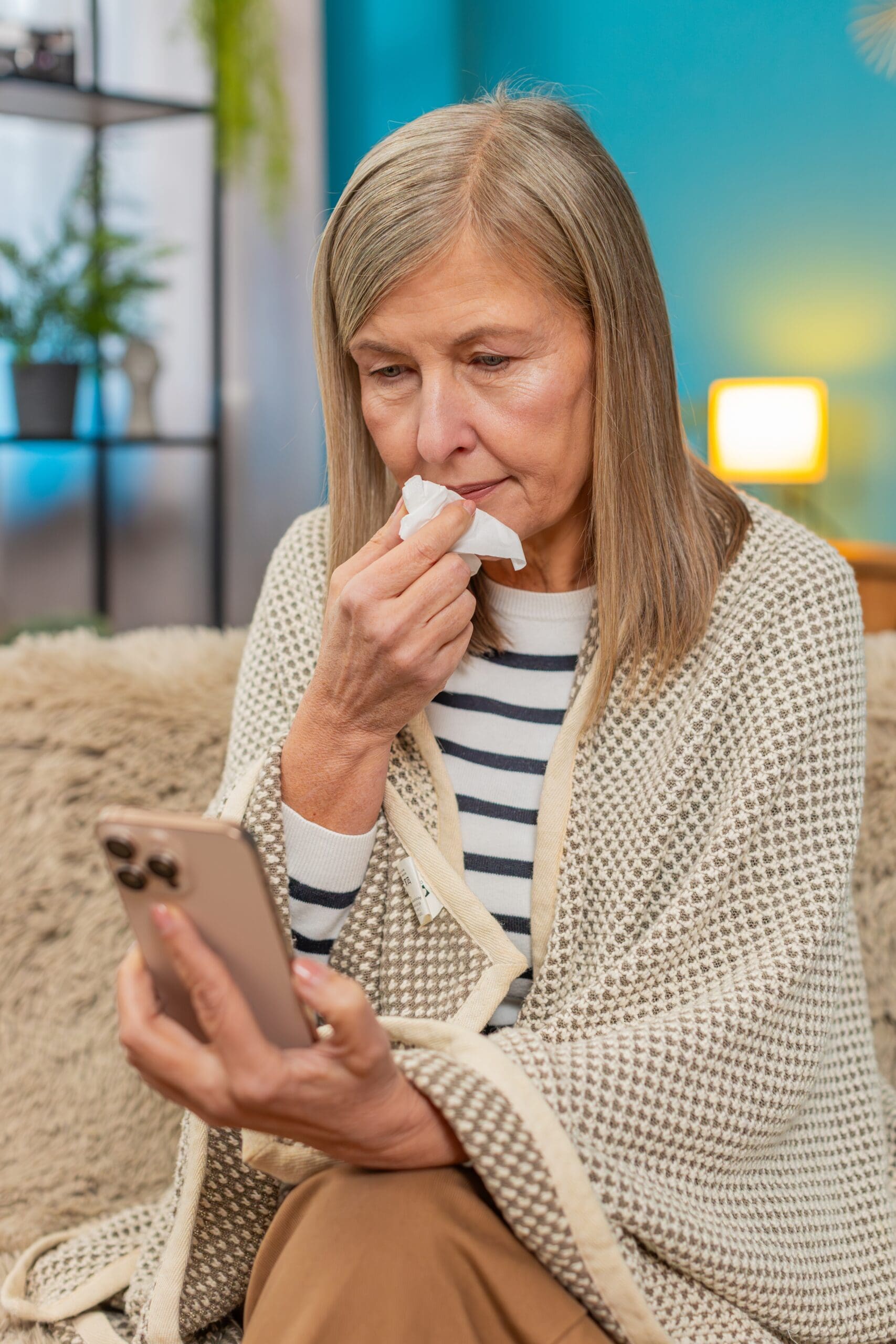old women watching phone and holding tissue paper Telehealth